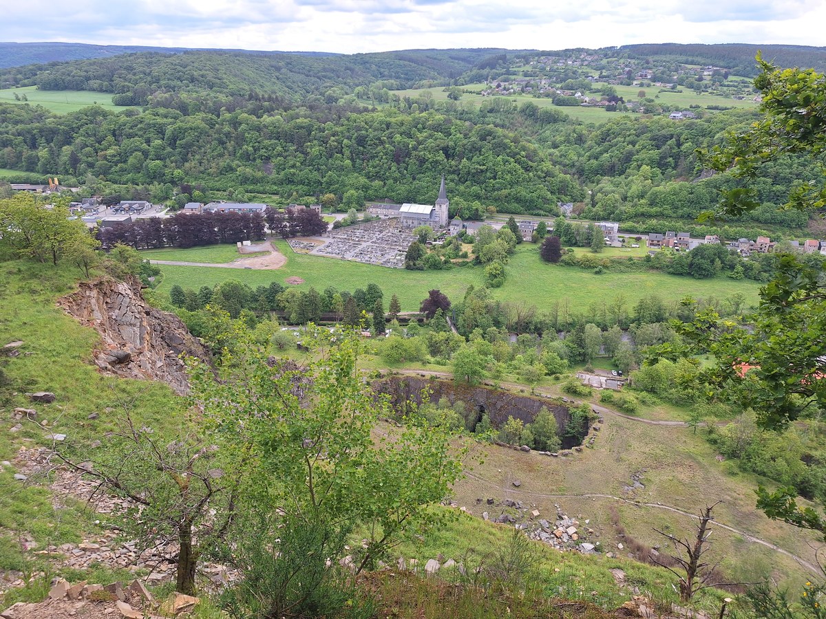 View from a hilltop at Heid Des Gattes over a deep former quarry pit and the village of Aywaille in the valley below