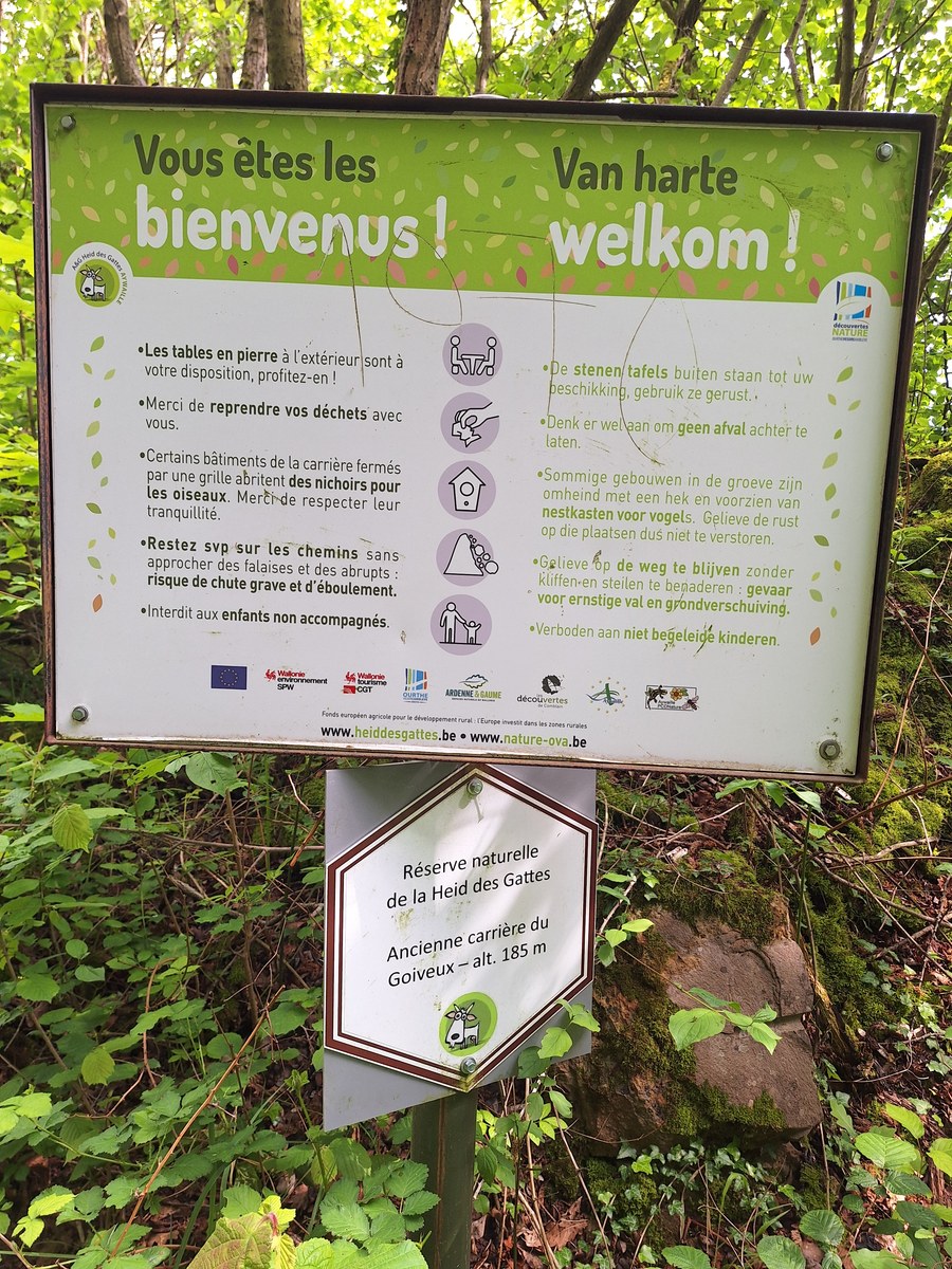 Welcome information panel for the Heid des Gattes nature reserve, with rules in French and Dutch and a smaller sign marking the former Goiveux quarry at 185 m altitude